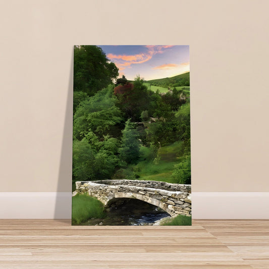 Stone arched bridge over a stream with lush greenery, rolling hills, and a pastel sunrise or sunset sky.